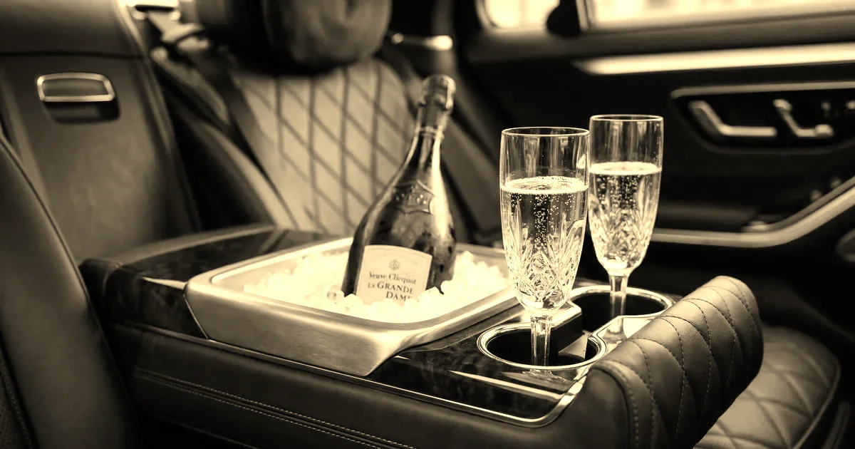 Service champagne à bord d’une berline de représentation, plateau et flûtes en cristal, traitement sépia presse B2B